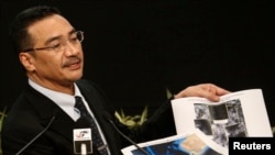 Menteri Pertahanan Malaysia, Hishammuddin Hussein, menunjukkan gambar satelit saat memberikan keterangan terkait pencarian pesawat MH370 dalam konferensi pers di Kuala Lumpur (26/3).