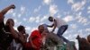 Des étudiants placent un seau sur la tête de la statue de Cecil John Rhodes, lors du retrait définitif de la statue du campus de l'université du Cap, en Afrique du Sud, le 9 avril 2015. (AP Photo/Schalk van Zuydam)