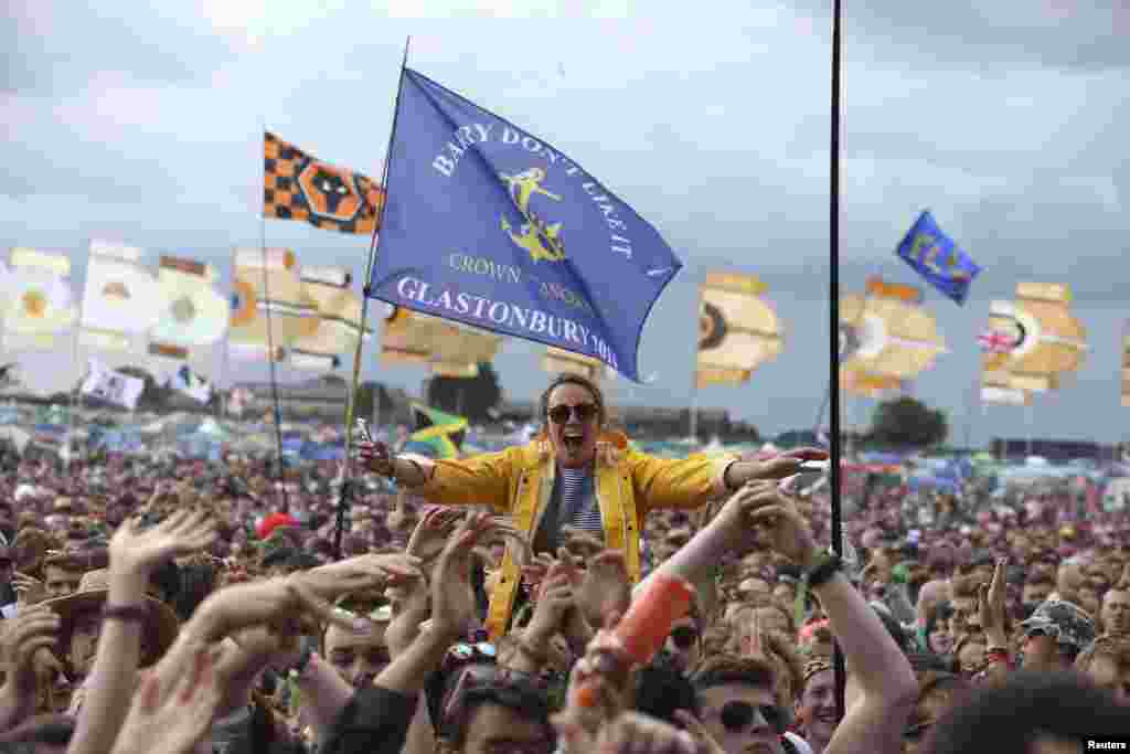 A festival-goer cheers in front of the Other Stage at Worthy Farm in Somerset, Great Britain, during the Glastonbury Festival. 