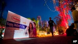 A man walks on a footpath decorated with lights and billboard by workers capital development authorities to observe International Mother's Day celebration in Islamabad, Pakistan, May 7, 2016. 