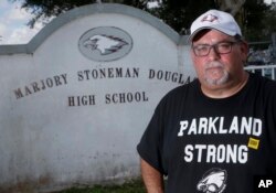 Stephen Feuerman poses for a photo in front of the Marjory Stoneman Douglas High School sign in Parkland, Fla., Aug. 27, 2018.
