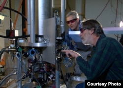 NIST physicists Steve Jefferts (front) and Tom Heavner with the NIST-F2 “cesium fountain” atomic clock, a new civilian time standard for the United States.