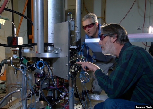 NIST physicists Steve Jefferts (front) and Tom Heavner with the NIST-F2 “cesium fountain” atomic clock, a new civilian time standard for the United States.