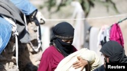 Seorang wanita membawa bayinya yang baru lahir di kamp yang diperuntukkan pengungsi akibat peperangan, dekat Sanaa, Yaman, 25 April 2017 (foto: REUTERS/Khaled Abdullah)