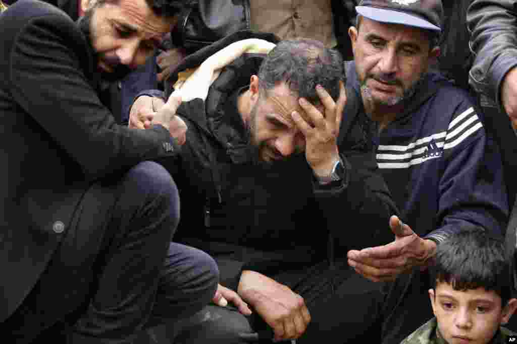 Syrian Maher al-Abdallah, center, mourns his wife and three children who died in their sleep after inhaling toxic fumes from burning coal to heat their room, during their funeral procession in Al-Wasta village near the southern port city of Sidon, Lebanon.