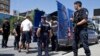 FILE - Kosovo police officers escort a Kosovo Albanian man suspected of fighting alongside Islamic radicals in Iraq and Syria to a local court in Pristina, Tuesday, Aug. 12, 2014. Kosovo police on Monday arrested at least 40 people in a major operation ta