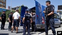 FILE - Kosovo police officers escort a Kosovo Albanian man suspected of fighting alongside Islamic radicals in Iraq and Syria to a local court in Pristina, Tuesday, Aug. 12, 2014. Kosovo police on Monday arrested at least 40 people in a major operation ta