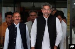 Pakistan's premier-designate Shahid Khaqan Abbasi, right, leaves with his aides after meeting with politicians in Parliament house in Islamabad, Pakistan, July 31, 2017.