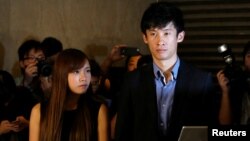 Democratically elected legislators Yau Wai-ching, left, and Baggio Leung meet journalists outside the High Court after the court disqualified them from taking office as lawmakers in Hong Kong, Nov. 15, 2016.