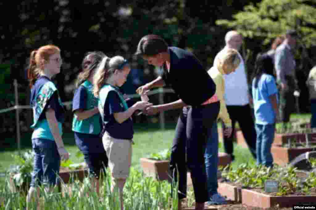 La primera dama Michelle Obama y las niñas del Escuadron 60325 de Girls Scout, de Fairport, Nueva York deciden cuales son las primeras semillas que van a sembrar. (Foto oficial de la Casa Blanca de Sonya N. Hebert)