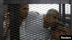 From left, Peter Greste, Mohamed Fahmy and Baher Mohamed listen to the ruling at a court in Cairo, Egypt, June 23, 2014.