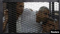 Dari kiri ke kanan: Jurnalis Peter Greste, Mohamed Fahmy dan Baher Mohamed saat mendengarkan keputusan pengadilan di Kairo, Mesir (23/6). (Reuters/Asmaa Waguih)