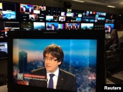 Ousted Catalan President Carles Puigdemont appears on a monitor during a live TV interview on a screen in a bar in Brussels, Belgium, Nov. 3, 2017.