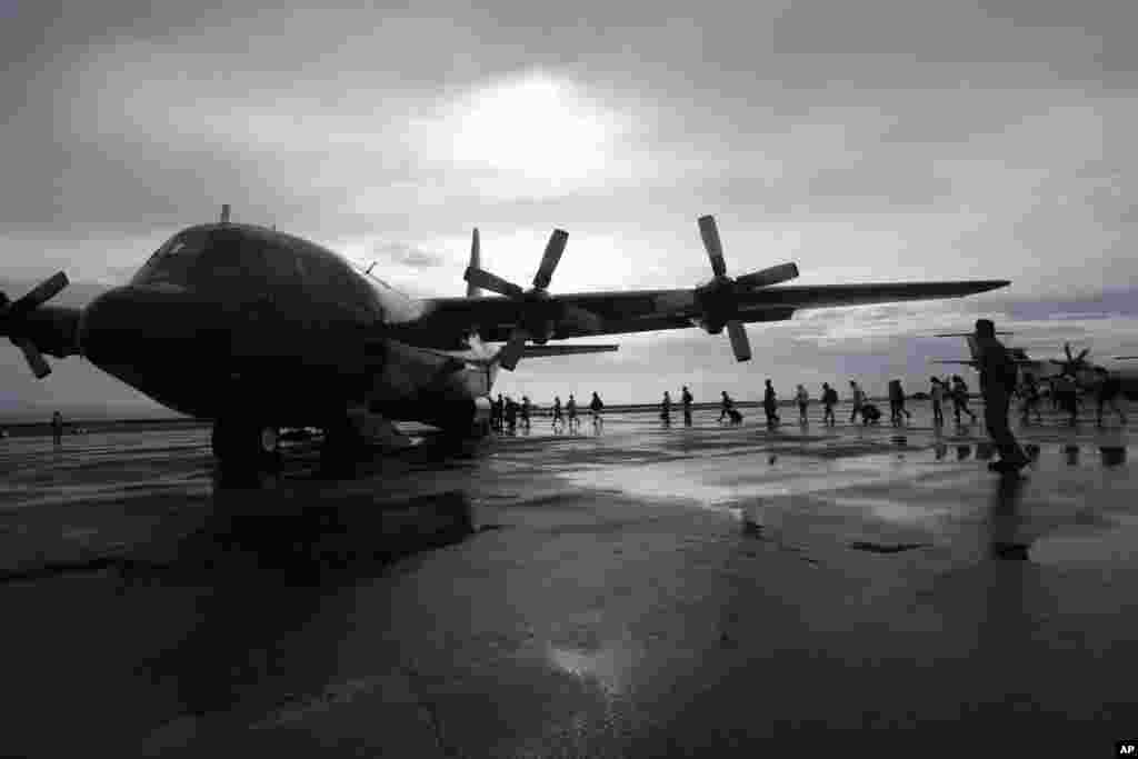 Typhoon survivors board a Philippine Air Force transport plane in Tacloban, Nov. 21, 2013.