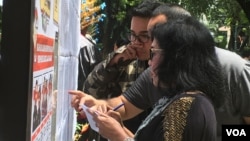 Warga memeriksa daftar pemilih dalam pemilihan gubernur Jakarta, di TPS Taman Suropati, Jakarta Pusat. (foto ilustrasi: VOA/Agus Sunarto)