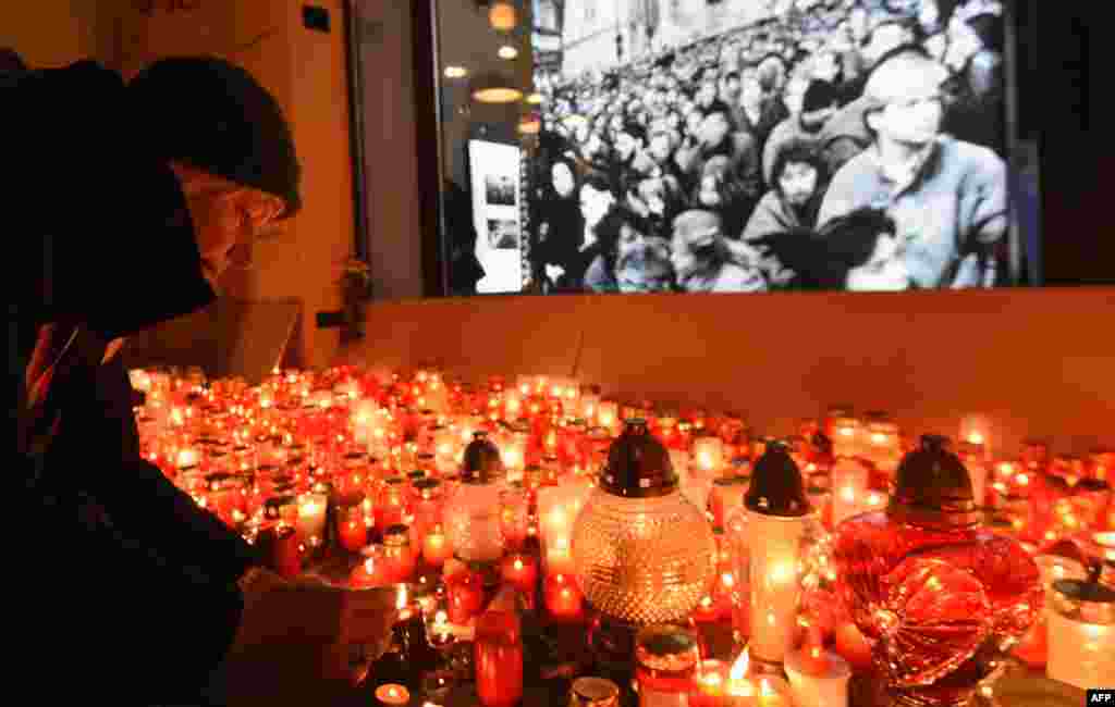 A woman lights candles to commemorate the 28th anniversary of the Velvet Revolution, in Prague, the Czech Republic.