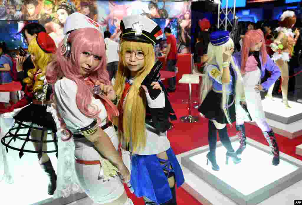 Models clad in costumes of video game characters pose at a game booth during the Tokyo Game Show 2016 in Chiba, suburb of Tokyo, Japan.