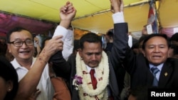 Meach Sovannara (C), a member of the Cambodia National Rescue Party (CNRP), cries next to CNRP President Sam Rainsy (L) and Deputy President Kem Sokha before a Buddhist ceremony at the CNRP office in Phnom Penh April 13, 2015. 