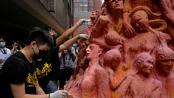 Mahasiswa membersihkan patung "Pilar Malu", peringatan bagi mereka yang tewas dalam penumpasan Tiananmen 1989, di Universitas Hong Kong, Jumat, 4 Juni 2021. (AP)