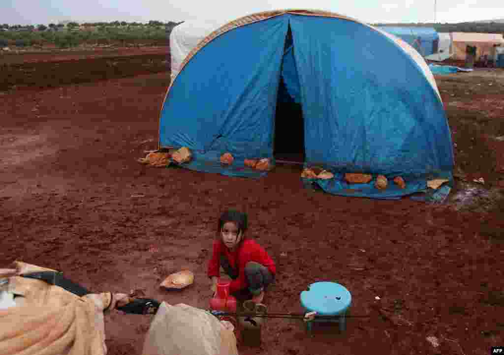 عکسی از کودک آواره سوری در اردوگاه گل آلود پناهجویان در ادلب سوریه.