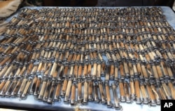 FILE - Tiger skin and bone products are laid out on a table by National Parks and Wildlife officers at the "Tiger Temple," in Saiyok district in Kanchanaburi province, west of Bangkok, Thailand, June 2, 2016.