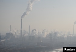 Smog streams from chimneys and cooling towers of a steel plant in Taiyuan, Shanxi province, China, December 28, 2016.