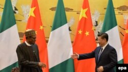 Muhammadu Buhari (L), President of the Federal Republic of Nigeria, and Chinese President Xi Jinping (R) reach out to shake hands during a signing ceremony at the Great Hall of the People, in Beijing, April 12, 2016. (Kenzaburo Fukuhara/EPA)