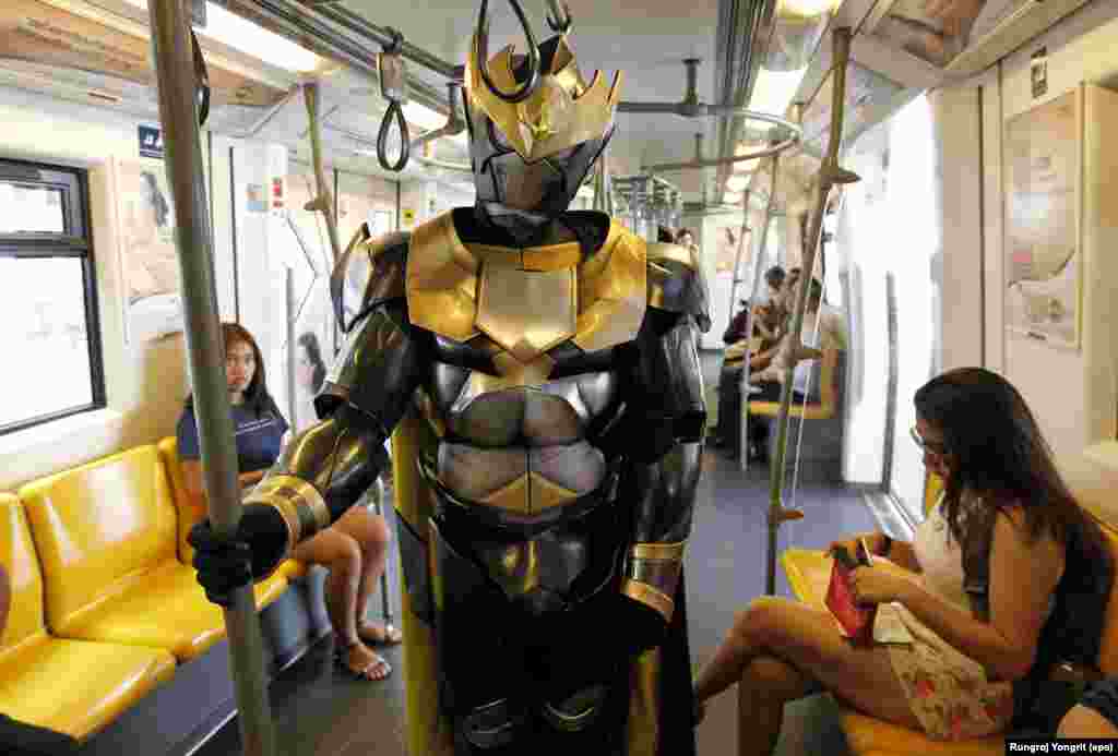 A Thai wearing costume of a robot character stands next to passengers on a Skytrain during a promotion of the upcoming Bangkok Entertainment Week 2016, in Bangkok, Thailand.