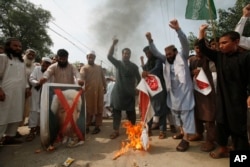 Pakistani protesters shout slogans to condemn a cartoon contest by Dutch parliamentarian, in Peshawar, Pakistan, Aug. 17, 2018.