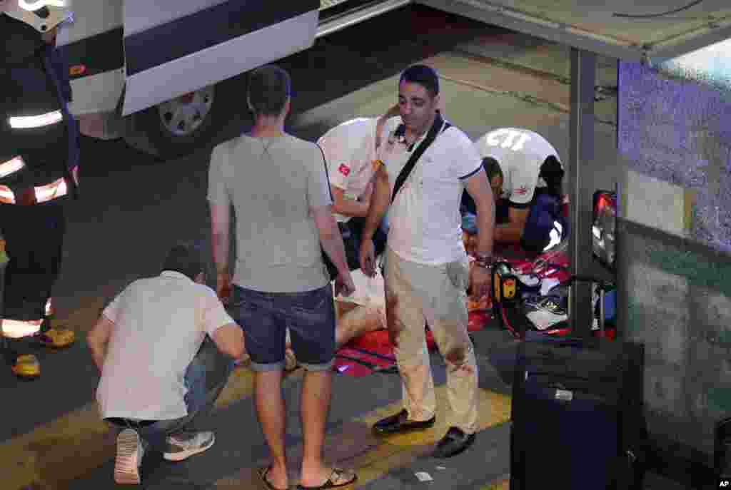 Turkish rescue services help a wounded person outside Ataturk Airport in Istanbul, June 28, 2016. Two explosions have rocked Istanbul's Ataturk airport, killing at least 28 people and wounding dozens of others, Turkey's justice minister and another offici