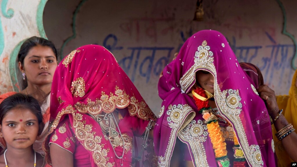 An underaged bride, right, stands with family members during her marriage at a Hindu religious building near Rajgarh, Madhya Pradesh state, India, April 17, 2017. (AP Photo/Prakash Hatvalne)