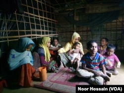 Samsun Nahar, a Rohingya widow, along with her 9 children at her bamboo-and-plastic shack in a refugee colony in Kutupalong, Cox’s Bazar, Bangladesh