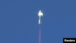 The New Shepard booster rocket, owned by Jeff Bezos' space company, Blue Origin, is shown at the moment of separation during the escape module testing in Culberson County, Texas, Oct. 5, 2016. 