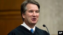 In this Aug. 7, 2018, photo. President Donald Trump's Supreme Court nominee, Judge Brett Kavanaugh, officiates at the swearing-in of Judge Britt Grant to take a seat on the U.S. Court of Appeals for the Eleventh Circuit in Atlanta at the U.S. District Courthouse in Washington.