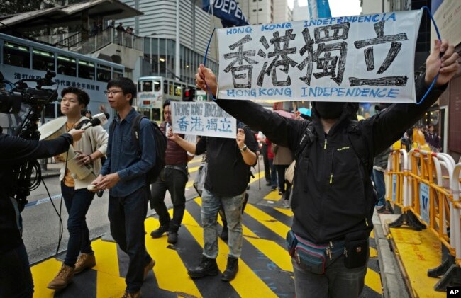 FILE - Protesters against an extradition law hold banners reading "Hong Kong Independence" during an anti-extradition law march toward government headquarters in Hong Kong, March 31, 2019.