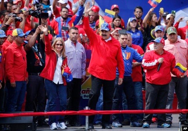 President Nicolas Maduro and first lady Cilia Flores greet supporters as they arrive at a rally in Caracas, Venezuela, Feb. 2, 2019.
