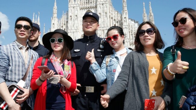2016年5月3日在意大利开始为期两周试验巡逻的中国警察与在米兰大教堂广场的中国游客合影。
