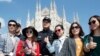 FILE - Chinese Police officer poses with Chinese tourists in Milan's Duomo square in Rome, Italy, May 3, 2016. 