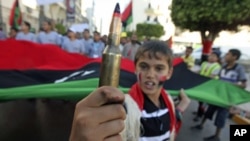 A boy holds a bullet while attending a rally where protesters were calling on the International Criminal Court to issue arrest warrants for Libyan leader Moammar Gadhafi, near the courthouse in Benghazi, Libya, May 14, 2011