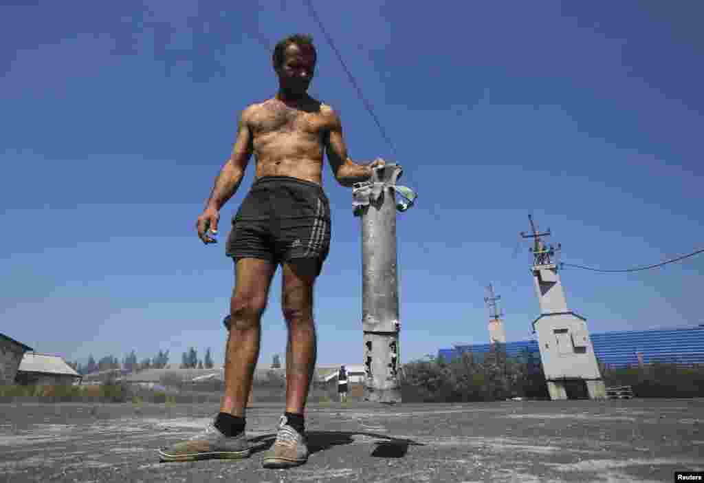 A man shows the remains of a military projectile in the village of Spartak outside Donetsk, Sept. 3, 2014.