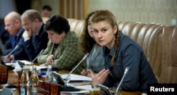 Public figure Maria Butina (R) attends a meeting of a group of experts, affiliated to the government of Russia, in this undated handout photo obtained by Reuters on July 17, 2018.