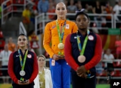 Netherlands' Sanne Wevers, center, gold, United States' Lauren Hernandez, left, silver, and United States' Simone Biles, right, stand after receiving their medals for balance beam at the 2016 Summer Olympics in Rio de Janeiro, Brazil, Aug. 15, 2016.