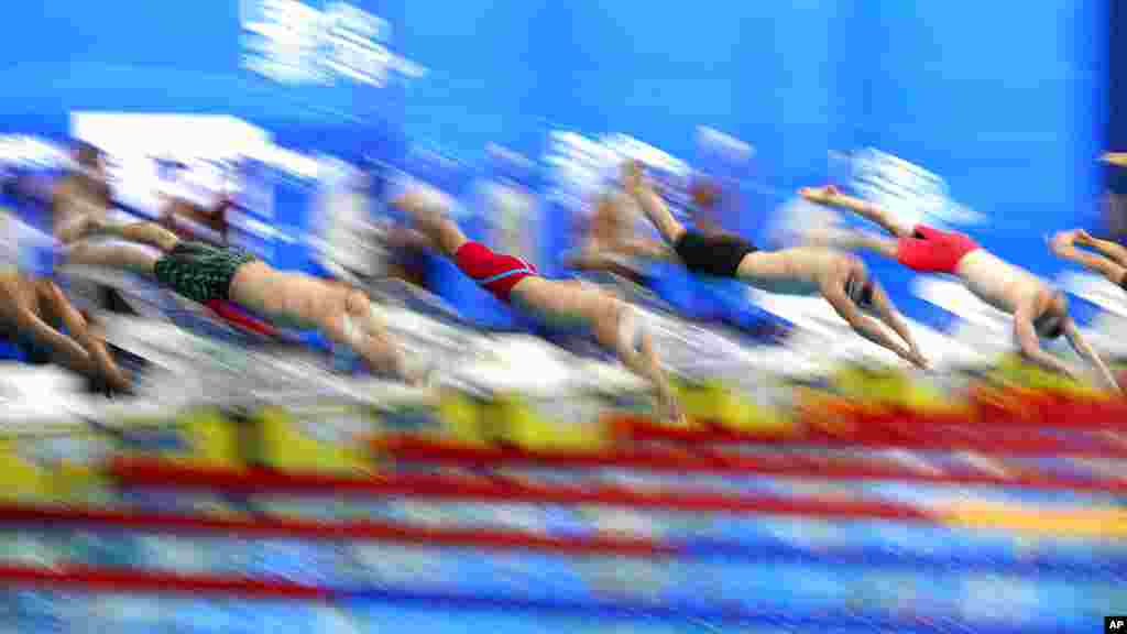 Swimmers jump in the pool at the beginning of the 400-meter relay men's final at the European Aquatics Championships in the Duna Arena in Budapest, Hungary.