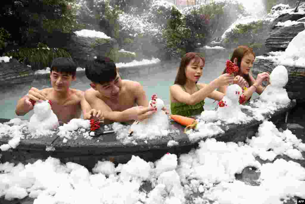 Visitors make snowmen beside a pool at a hot spring in Hangzhou, in China's eastern Zhejiang province.