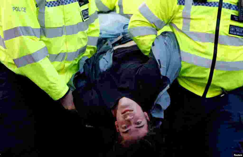 Police detain a protester as climate change activists demonstrate during an Extinction Rebellion protest at the Waterloo Bridge in London, Britain, April 15, 2019. 