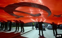 Russian military cadets hold a giant replica of the Soviet flag as part of preparations for Victory Day, in Saint Petersburg, Russia, May 5, 2017. There are concerns that by involving youth in organizations like Yunarmiya, Russian authorities are looking to militarize a new generation of nationalists.