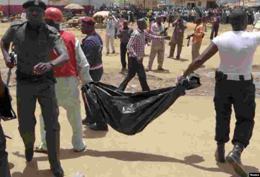 Rescue personnel recover mangled bodies wrapped in black polythene at the site of a bomb blast at This Day newspaper premises in Abuja April 26, 2012.