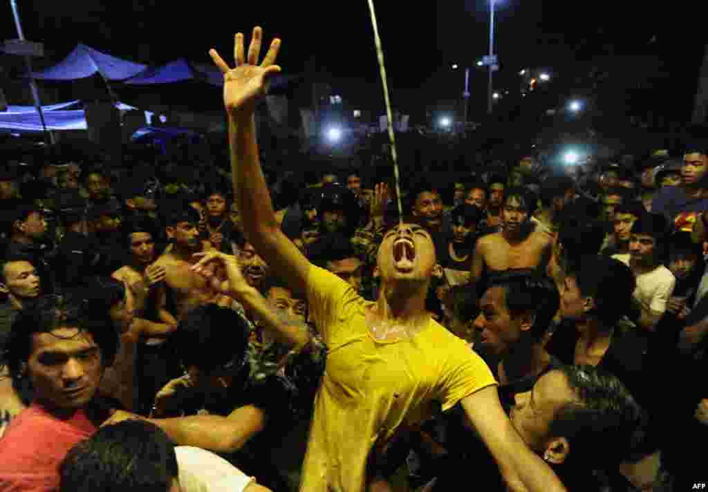 Nepalese youth drink wine poured on the second day of the Indra Jatra Festival in Kathmandu.