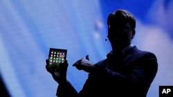 SJustin Denison, SVP of Mobile Product Development, shows off the Infinity Flex Display of a folding smartphone during the keynote address of the Samsung Developer Conference Wednesday, Nov. 7, 2018, in San Francisco. (AP Photo/Eric Risberg)