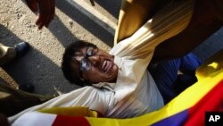 Police officers detain a Tibetan exile during a protest outside the venue where Chinese Premier Wen Jiabao is addressing a gathering on India-China relations in New Delhi December 16, 2010. Wen pressed on with a charm offensive in India on Thursday, offer